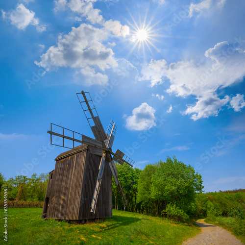 small wooden windmill among green rural fields