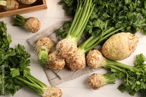 Fresh raw celery roots on white wooden table, flat lay photo