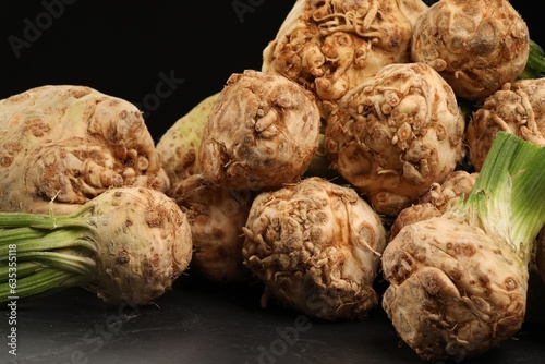 Fresh raw celery roots on black table, closeup