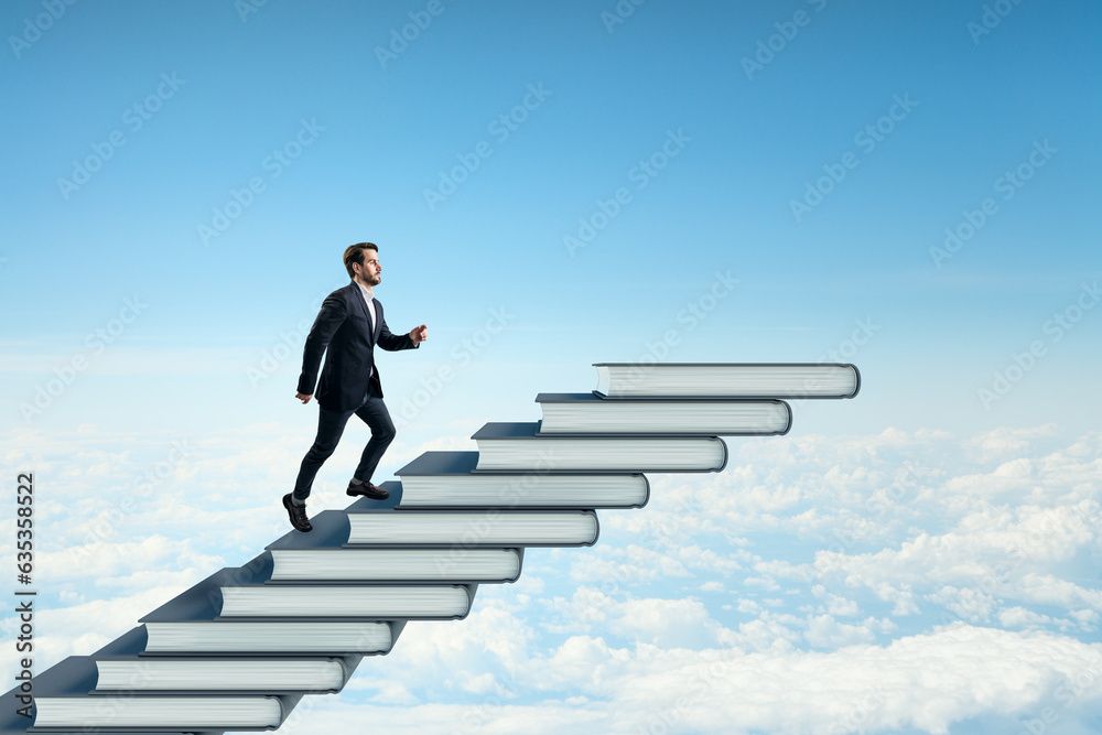 Side view of young businessman climbing book steps on bright blue sky with clouds background. Mock up place. Growth and education concept.