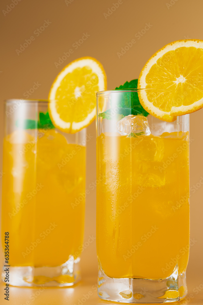 Refreshing orange cocktail with ice in glasses. Close-up. Vertical frame. Refreshing orange cocktail with ice in glasses. Close-up. Vertical frame.
