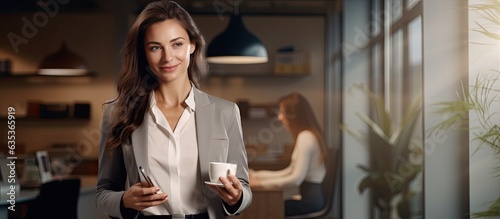 A Caucasian businesswoman in her office confidently using her phone while holding a coffee cup