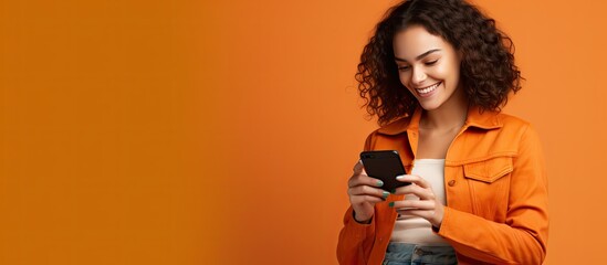 Happy woman in casual denim outfit posing on orange wall background in a studio portrait Representing people s lifestyle with a mock up copy space Using a