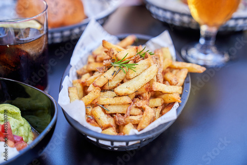 Delicious French Fries in black basket placed on table