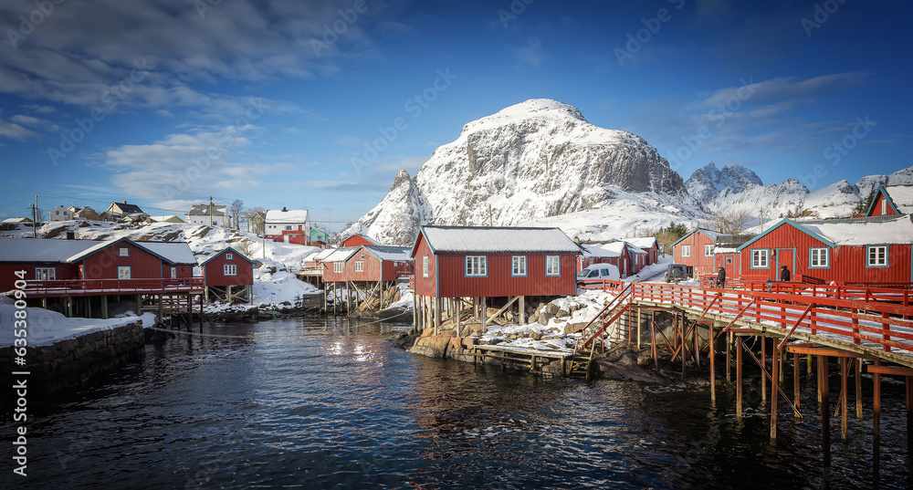 Amazing winter seascape. Nusfjord authentic fishing village with traditional red rorbu houses in winter sunny day. Lofoten islands, Norway. Typical north scenery of Lofoten islands. Norway