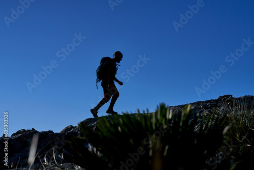 Silhouette of traveling man on rocky hill