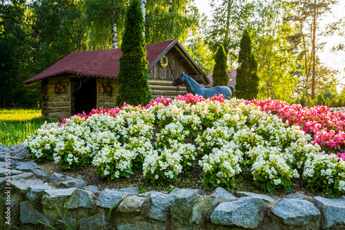 Obraz na płótnie Park z drzewami liściastymi, pięknymi trawnikami, klombami kolorowych kwiatów i alejkami. Lato na Śląsku w Polsce, Rogów gmina Gorzyce. w salonie