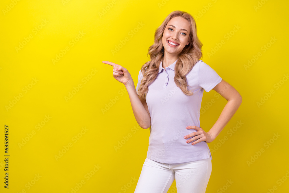 Portrait of lovely positive lady beaming smile direct finger empty space ad blank isolated on yellow color background Portrait of lovely positive lady beaming smile direct finger empty space ad blank isolated on yellow color background