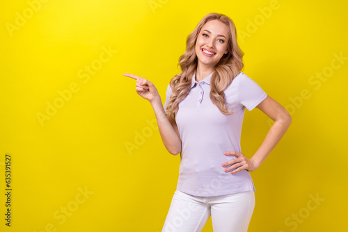 Portrait of lovely positive lady beaming smile direct finger empty space ad blank isolated on yellow color background