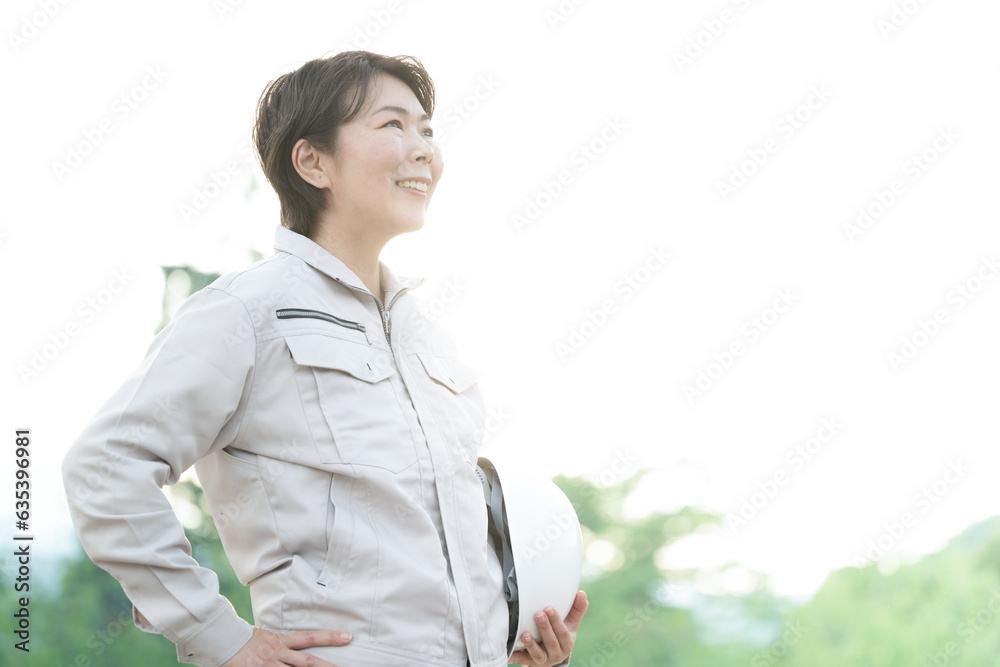作業着を着た中年女性 女性の現場監督など 見上げる横顔 未来や希望のイメージ 作業着を着た中年女性 女性の現場監督など 見上げる横顔 未来や希望のイメージ