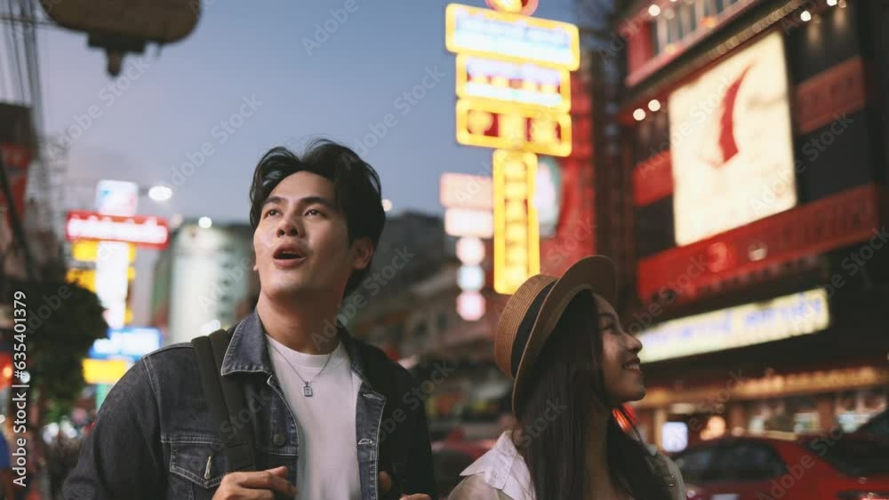 Young Asian couple enjoy and have fun outdoor lifestyle together in street market on summer holiday vacation in bangkok, thailand. Happy man and woman feeling surprise about how beautiful the city is Young Asian couple enjoy and have fun outdoor lifestyle together in street market on summer holiday vacation in bangkok, thailand. Happy man and woman feeling surprise about how beautiful the city is