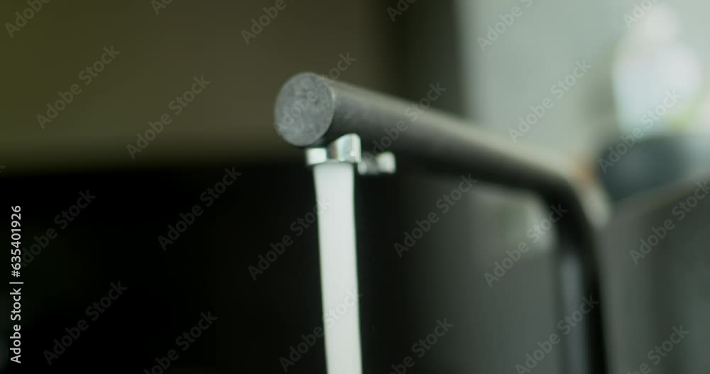 Water flows from a modern kitchen faucet. Slider shot Water flows from a modern kitchen faucet. Slider shot