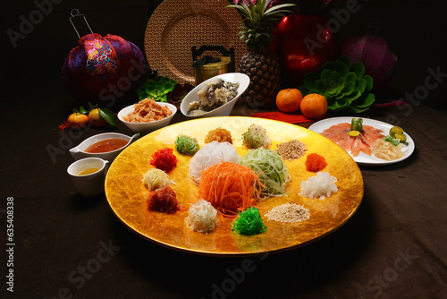 fresh colourful asian festive vegetables salad lo hei yu sheng with smoked salmon, fish skin, cookies and sweet spicy sauce buffet corner for chinese new year halal food menu for banquet restaurant photo