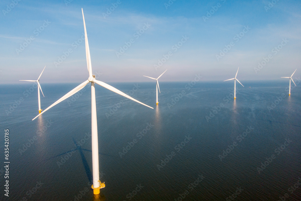 Wind mill park with clouds and a blue sky, windmill turbines in the ocean Wind mill park with clouds and a blue sky, windmill turbines in the ocean