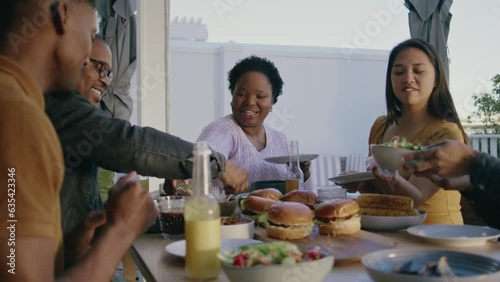 Five Friends Sitting Around A Table Sharing a Meal