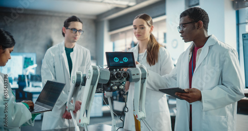 Diverse Team of Industrial Robotics Specialists Gathered Around a Table With Mobile Robot. Engineers In Lab Coats Discussing an Automated AI Robotic Dog  Using Laptop and Tablet and Brainstorming.