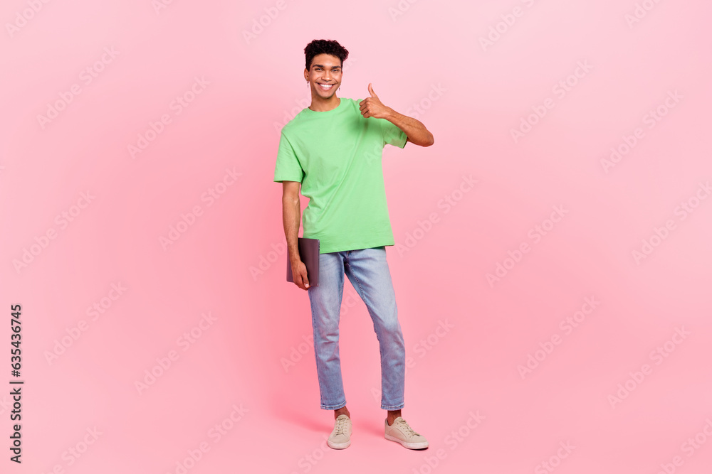 Fototapeta premium Full length photo of satisfied man dressed stylish t-shirt holding laptop showing thumb up nice work isolated on pink color background