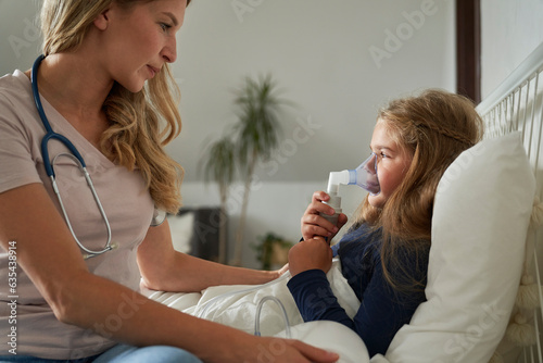 Doctor giving nebulizer to an ill child at home