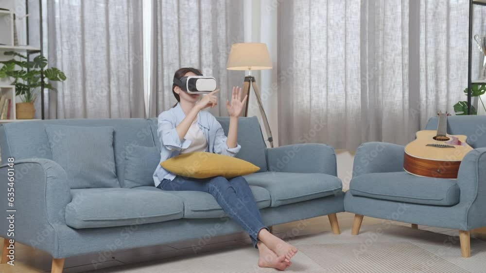Full Body Of Asian Teen Girl Sitting On Sofa In The Living Room At Home, Touching Air Panel And Swiping Virtual Reality With Hand While Using Futuristic Goggles
Full Body Of Asian Teen Girl Sitting On Sofa In The Living Room At Home, Touching Air Panel And Swiping Virtual Reality With Hand While Using Futuristic Goggles