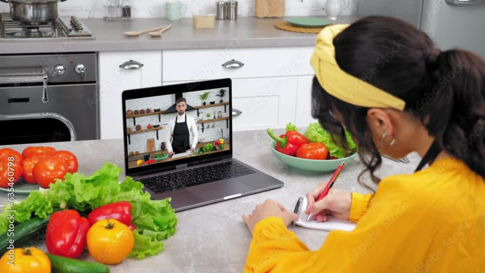 Man chef food blogger in computer screen greets tells recipe dish teaches housewife cooking culinary lesson. Woman in kitchen study online video call webcam laptop listen teacher writes in notebook