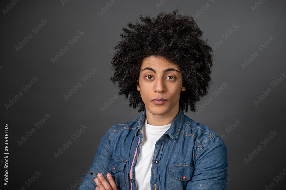 Waist up of a curly-haired young man on grey background Waist up of a curly-haired young man on grey background