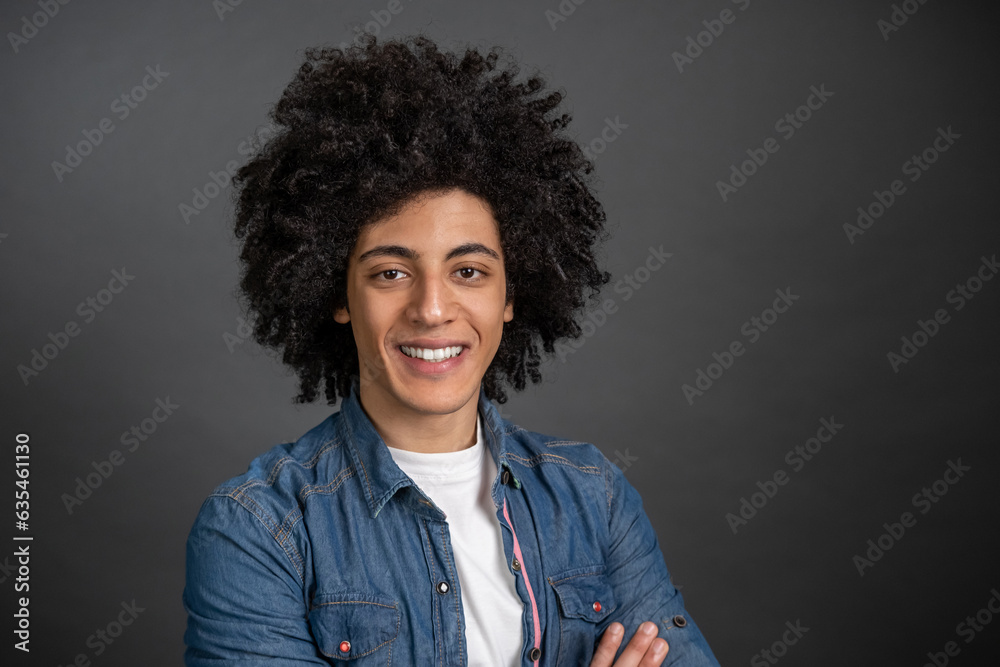 © zinkevych - Waist up of a curly-haired young man on grey background © zinkevych - Waist up of a curly-haired young man on grey background