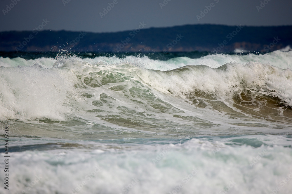 Fototapeta premium Abstract landscape with sea waves at the shore on a windy day.