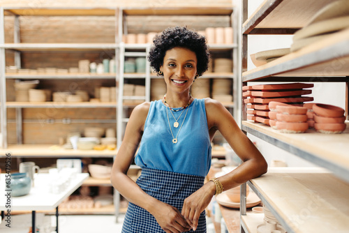 Successful female potter smiling at the camera in her shop photo