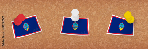 Guam flag pinned in cork board, three versions of Guam flag.