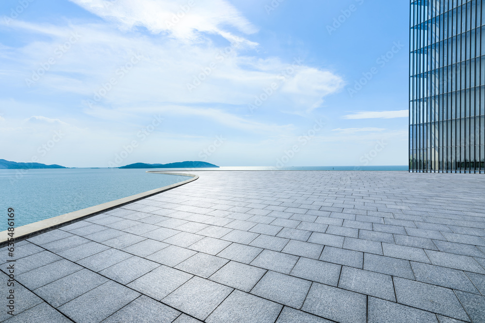 Empty square floor and lake under blue sky