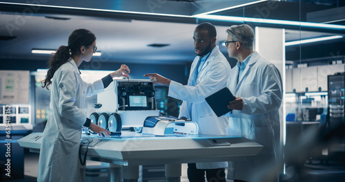 Diverse Team of Industrial Robotics Specialists Gathered Around Table With a Mobile Robot. Engineers In Lab Coats Discussing an Automated Robotic Delivery Machine with Artificial Intelligence