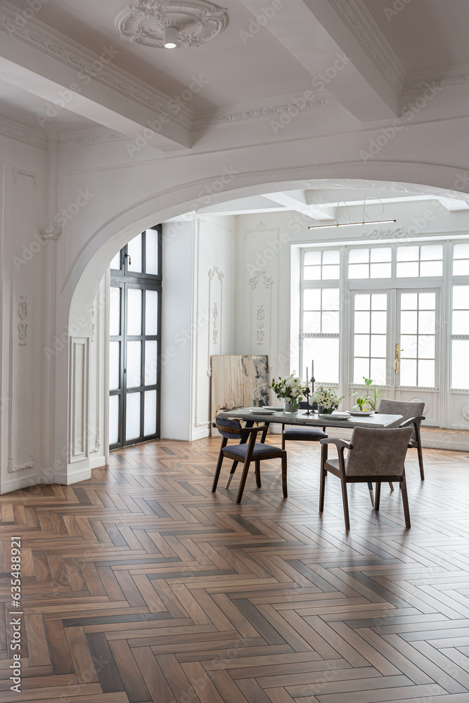 a chic expensive bright interior of a huge living room in a historic mansion with arched arches, columns and white walls decorated with ornaments and stucco. a chic expensive bright interior of a huge living room in a historic mansion with arched arches, columns and white walls decorated with ornaments and stucco.