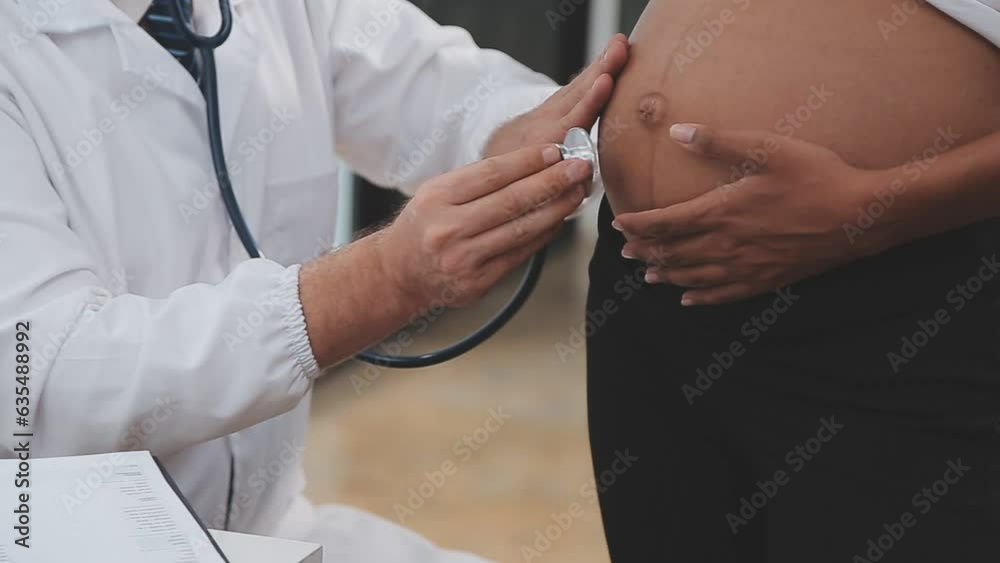 Prenatal health care. Close up of young pregnant woman visiting doctor at antenatal clinic. Medic gynecologist examine fetal heartbeat rate moving stethoscope by naked baby bump of expectant mother Prenatal health care. Close up of young pregnant woman visiting doctor at antenatal clinic. Medic gynecologist examine fetal heartbeat rate moving stethoscope by naked baby bump of expectant mother