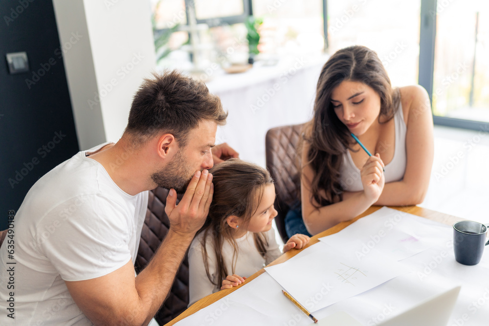 Dad whispers to his daughter the answer to a homework question so that mom does't hear, mom, dad and daughter are sitting at a messy table Dad whispers to his daughter the answer to a homework question so that mom does't hear, mom, dad and daughter are sitting at a messy table