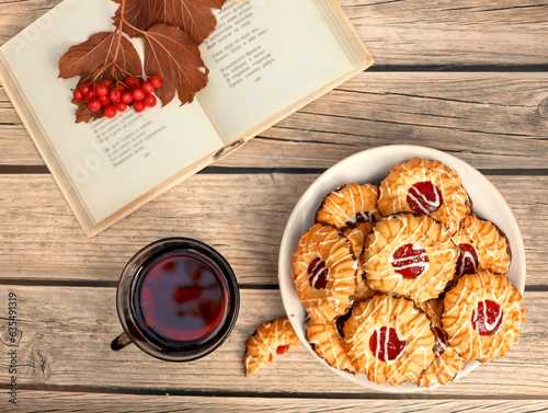 Tea with qurabiya sand cookies while reading book in fall garden. Autumn dessert. top view. photo