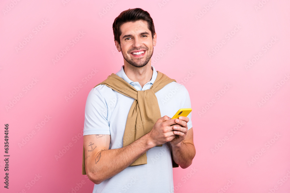 Photo of cheerful friendly person beaming smile hold use smart phone texting isolated on pink color background Photo of cheerful friendly person beaming smile hold use smart phone texting isolated on pink color background