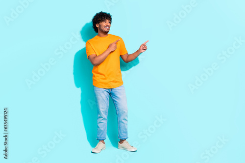 Full size body photo of young advertiser banner man direct fingers novelty proposition interested ad isolated on aquamarine color background