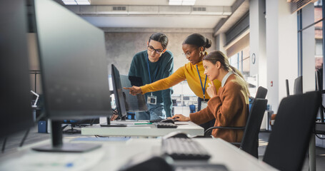 Team of Diverse Female and Male Students Having a Conversation in Computer Class, Working on a College Assignment. Young Classmates Talking, Thinking About a Successful Software Development Project