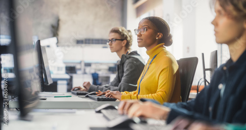 Young Inspired Black Female Student Studying in College with Diverse Multiethnic Classmates. African Girl Listening to Teacher, Using Computer to Apply Her Knowledge to Acquire New IT Skills in Class