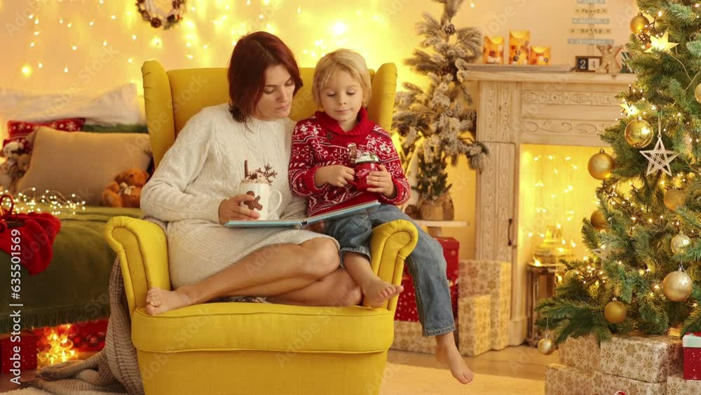 Cute child and mom, reading a book in a decorated room for Christmas, cozy place Cute child and mom, reading a book in a decorated room for Christmas, cozy place