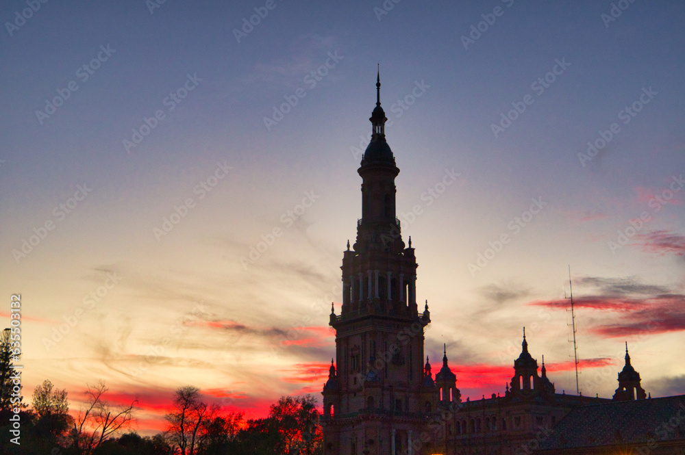 Night view of the monument of plaza de spain in seville, spain. Reddish sky at sunset in the city.