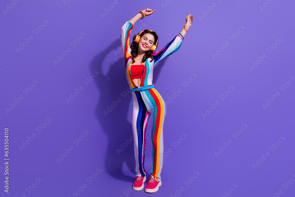 Photo of positive cheerful lady listen music dancing with hands up enjoying playlist isolated purple color background