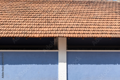 Exterior facade of an old house with traditional tiled roofs and light blue walls in a village in coastal Karnataka. photo