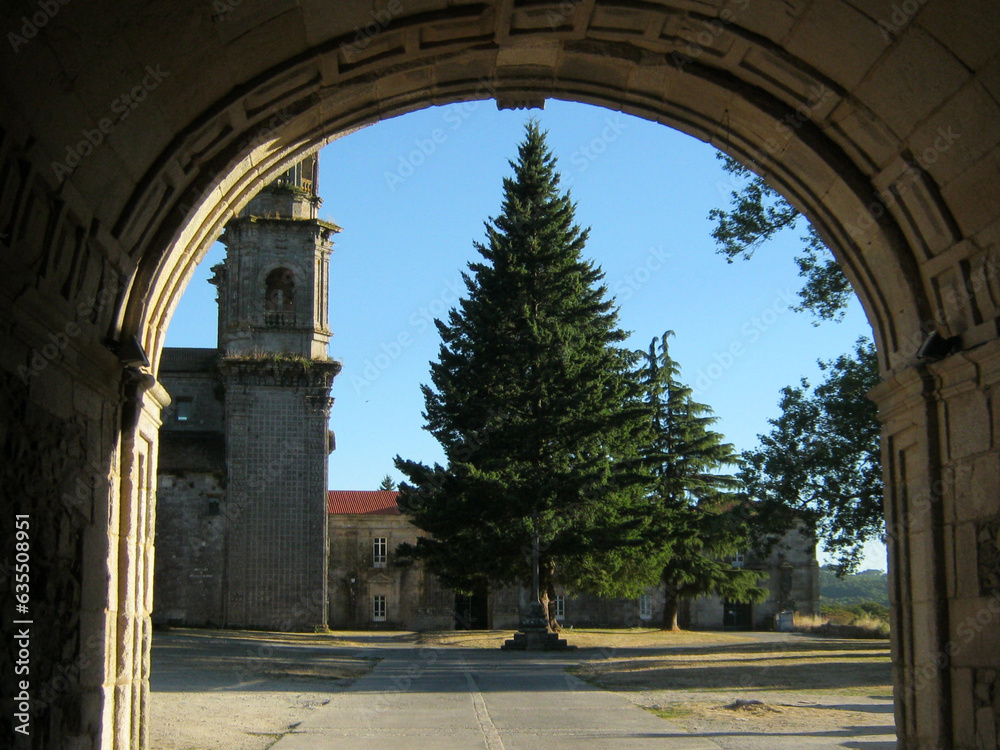 view into the courtyard with spruce trees through the archway