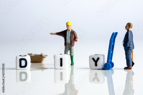 diy word or concept made by white letter cubes on white and gray background, do it yourself abbreviation with miniature figurines constructing the concept