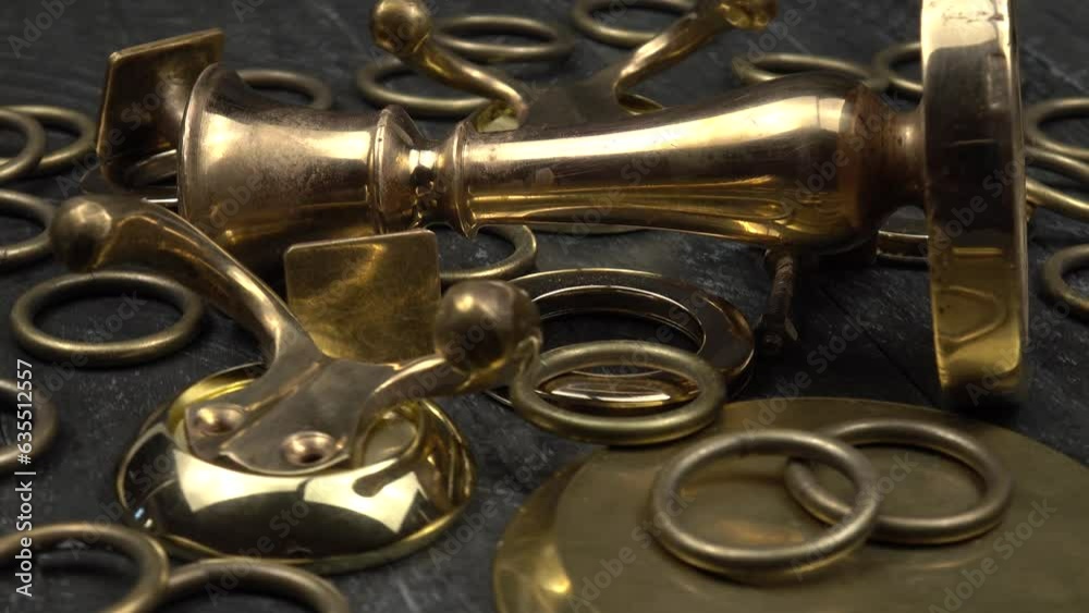 Various household items made of brass and bronze lie on a dark wooden board Various household items made of brass and bronze lie on a dark wooden board