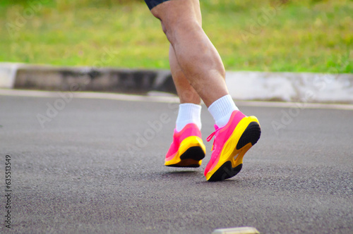 Detail of the legs of a runner exercising on the street at dawn