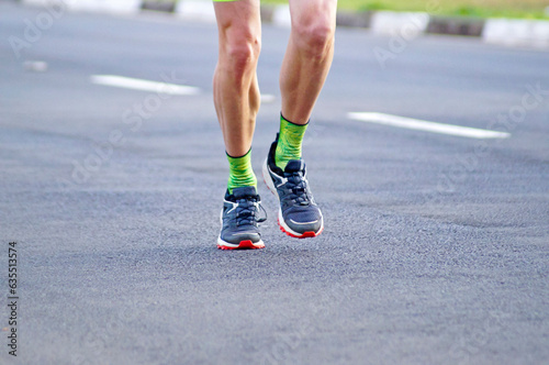 Detail of the legs of a runner exercising on the street at dawn