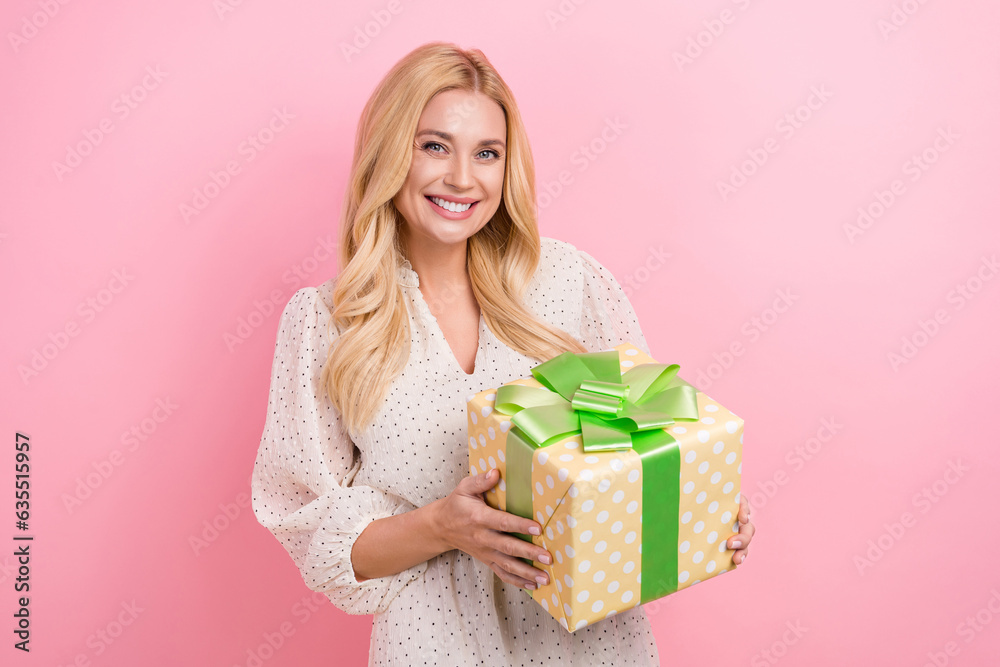 Photo portrait of lovely blonde woman hold big present box celebrate birthday wear trendy white garment isolated on pink color background Photo portrait of lovely blonde woman hold big present box celebrate birthday wear trendy white garment isolated on pink color background