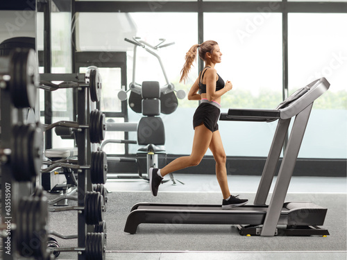 Young female running on a treadmill at a gym